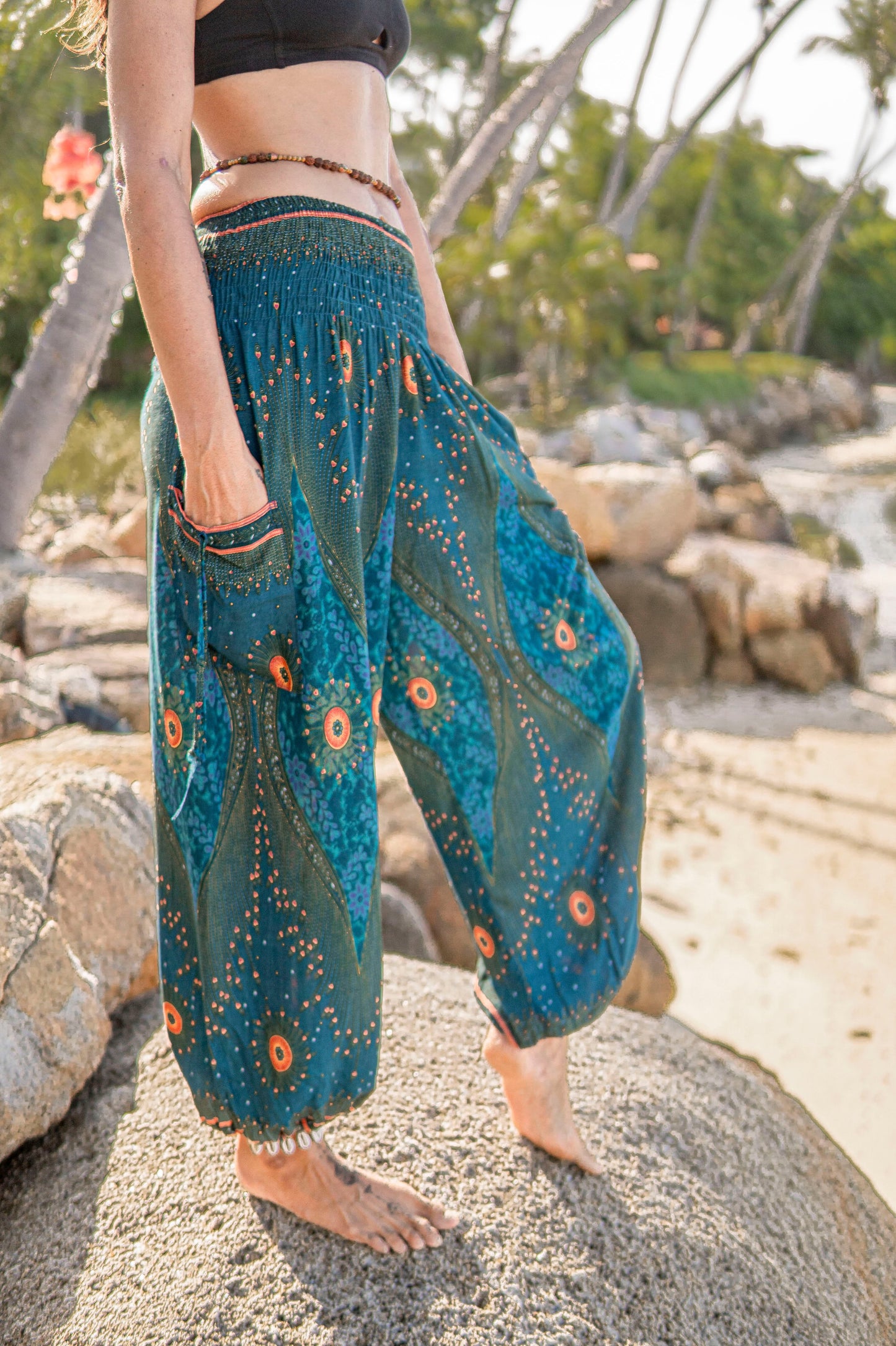 Airy harem pants with a peacock pattern in turquoise