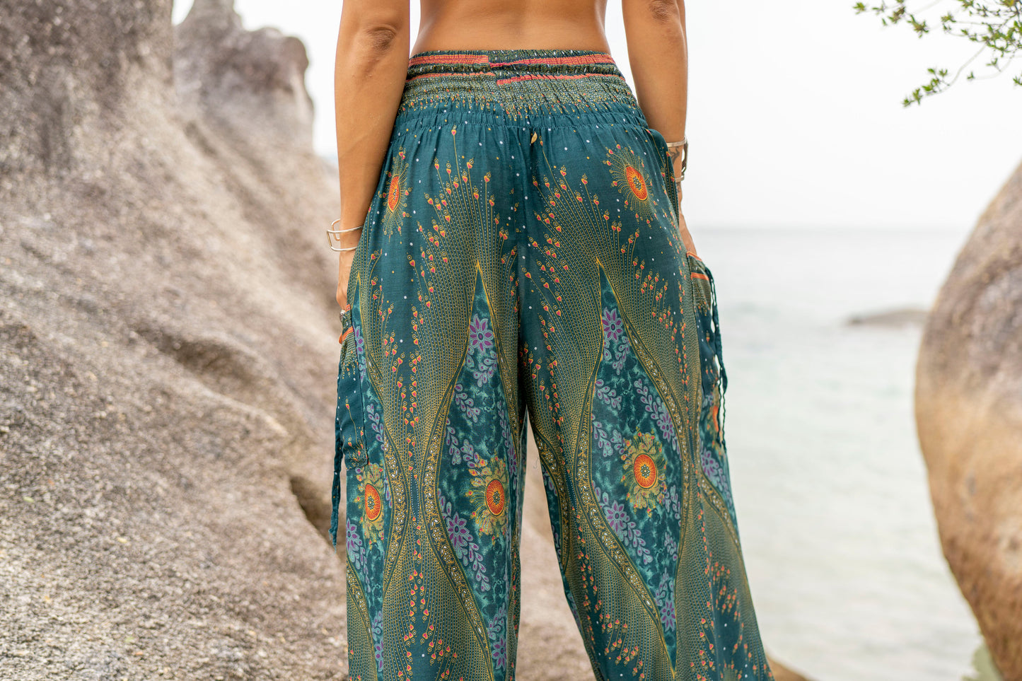 Airy harem pants with a peacock pattern in turquoise