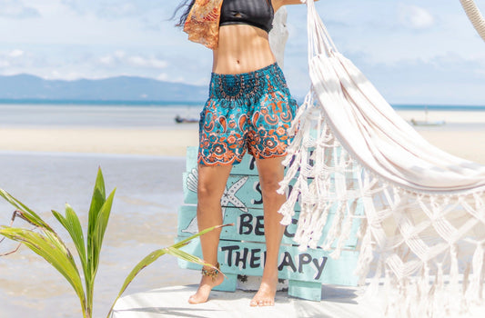 Airy, light summer shorts with colorful patterns in turquoise/orange