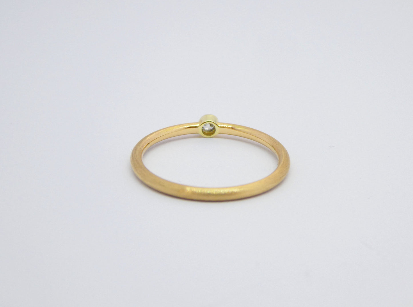 narrow handcrafted gold ring with diamond