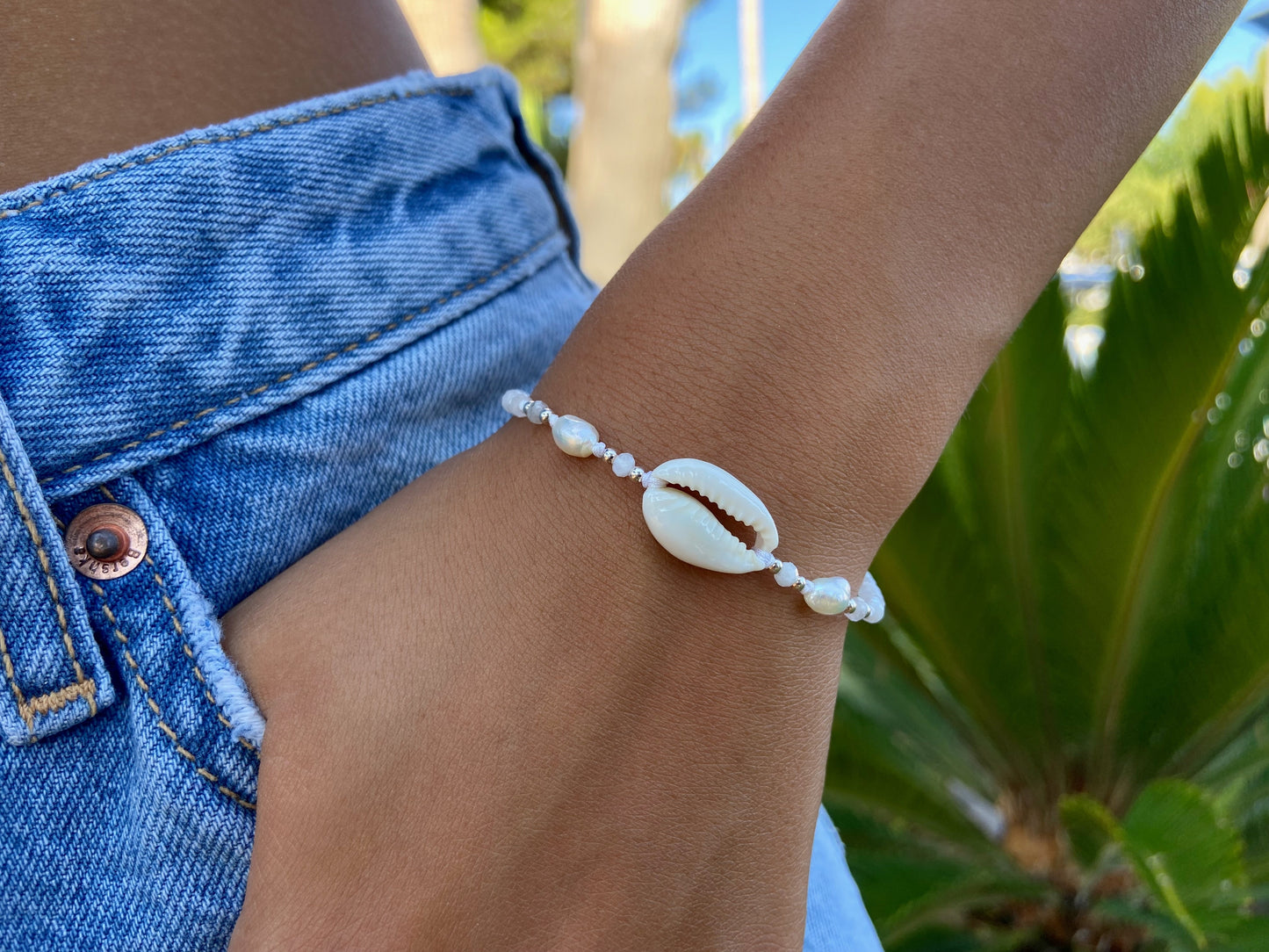 white bracelet with cowrie shell, moonstones, silver elements and freshwater pearls