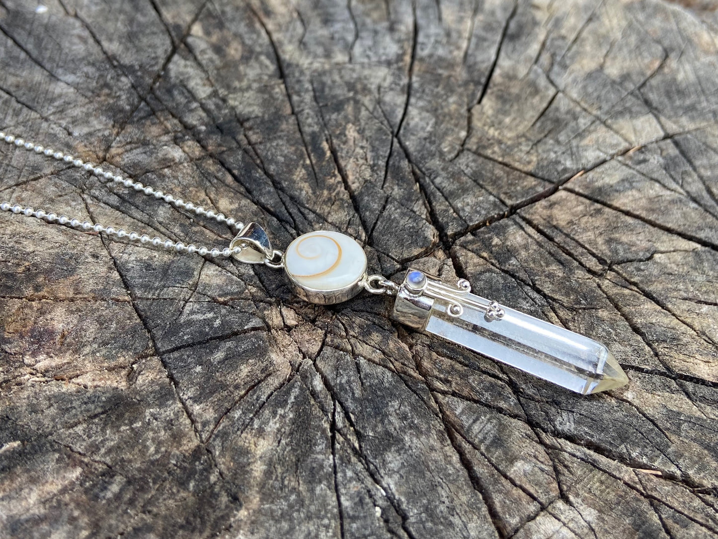 Pendant rock crystal with operculum with spirals, dots and small stone, silver
