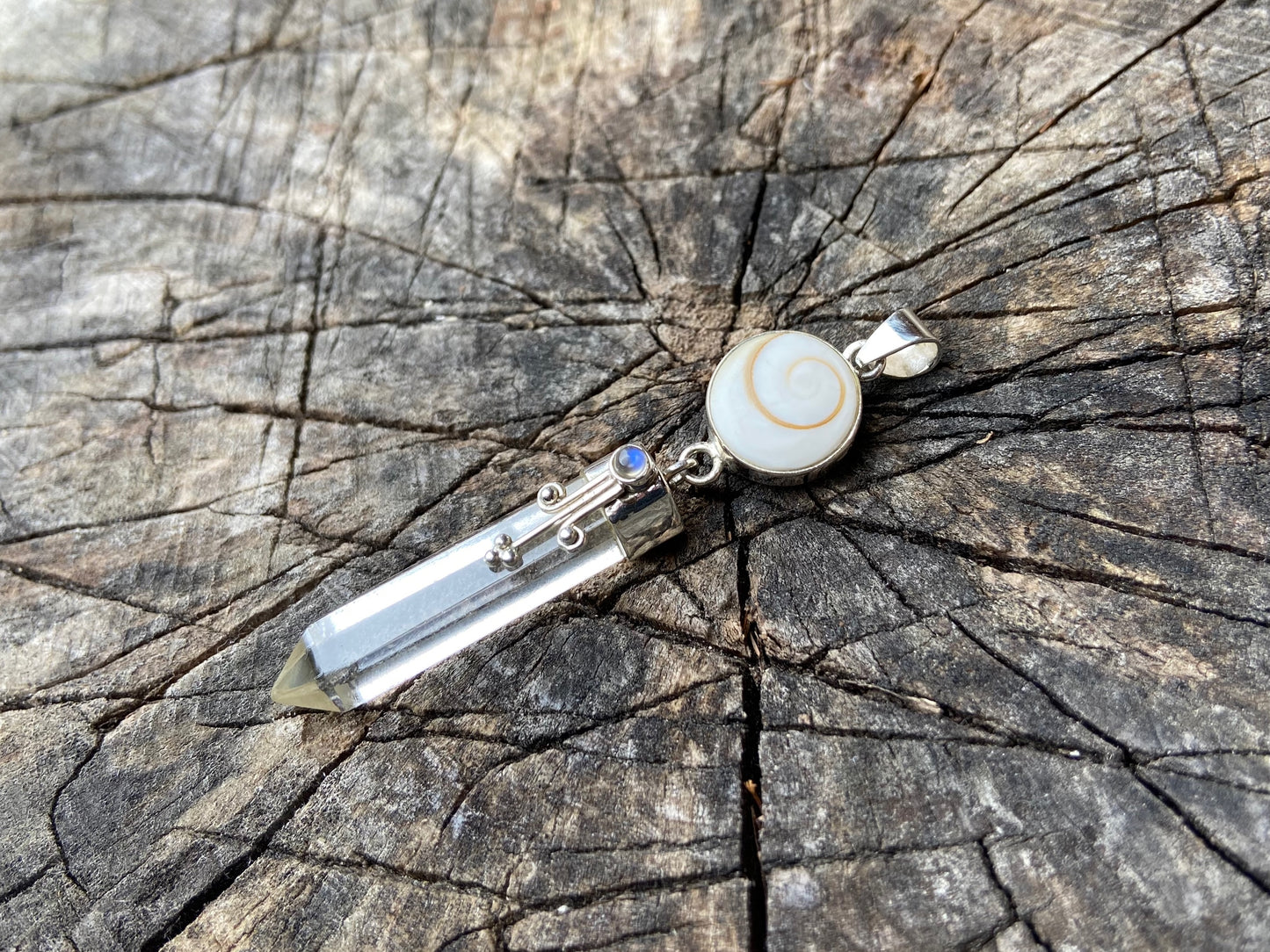 Pendant rock crystal with operculum with spirals, dots and small stone, silver