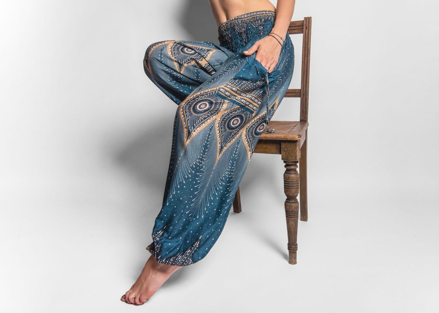 Airy harem pants with a peacock pattern in turquoise