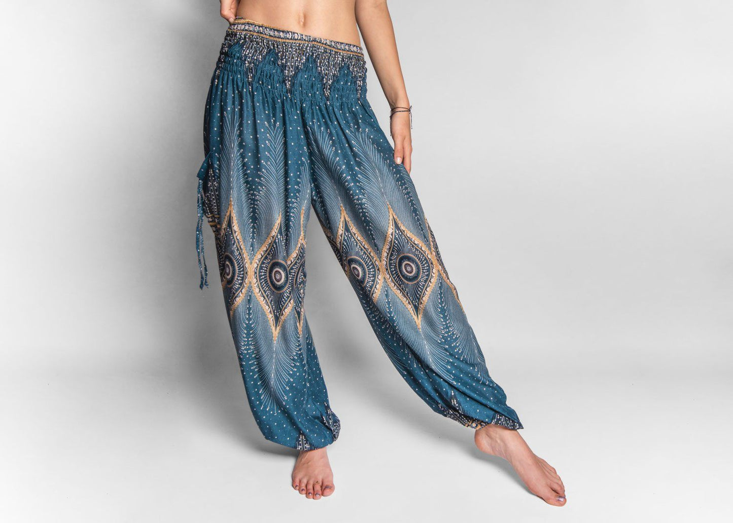 Airy harem pants with a peacock pattern in turquoise