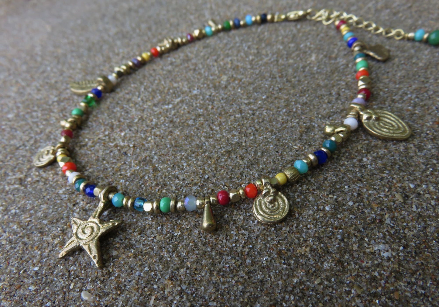 colorful anklet with various small brass pendants
