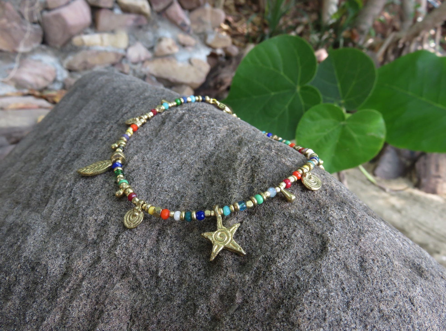 colorful anklet with various small brass pendants