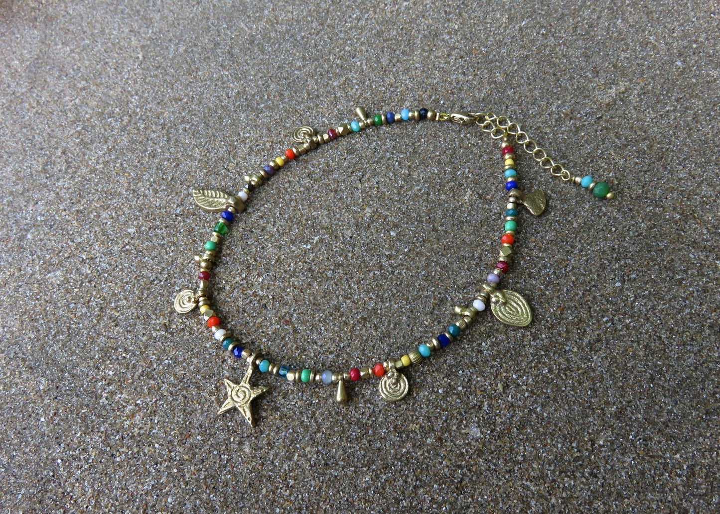colorful anklet with various small brass pendants