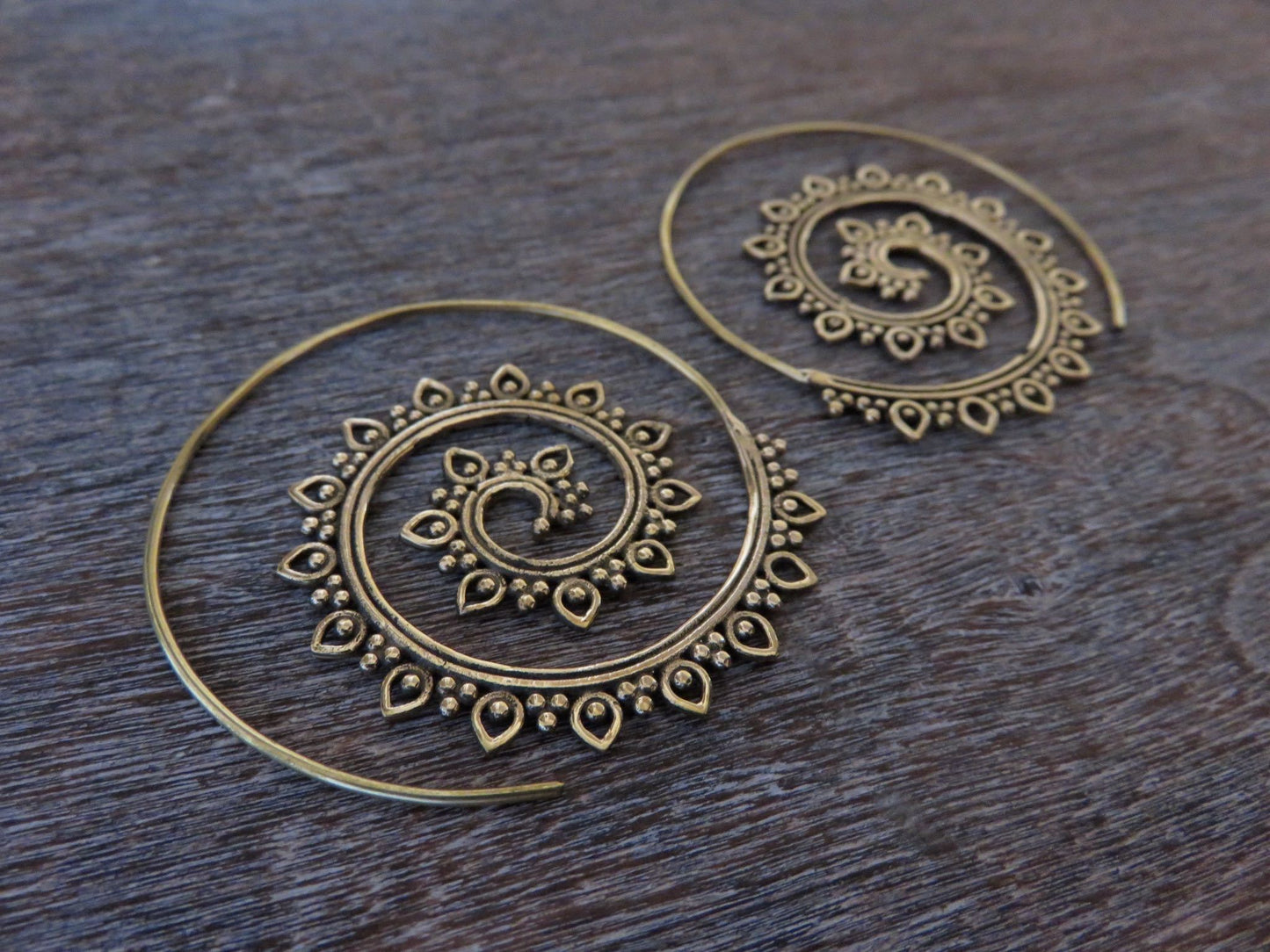 large spiral earrings with a filigree pattern made of brass