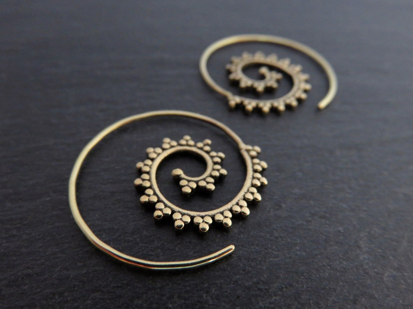 small spiral earrings patterned with small dots made of brass