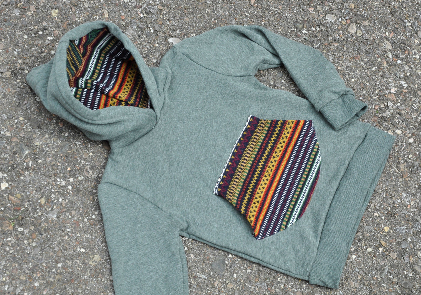 Children's sweater with colorful pocket and green hood lining