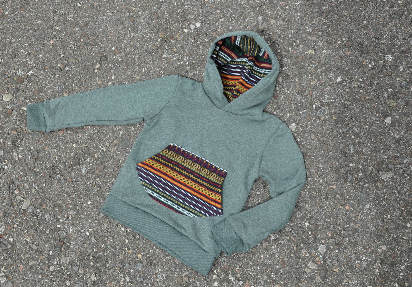 Children's sweater with colorful pocket and green hood lining