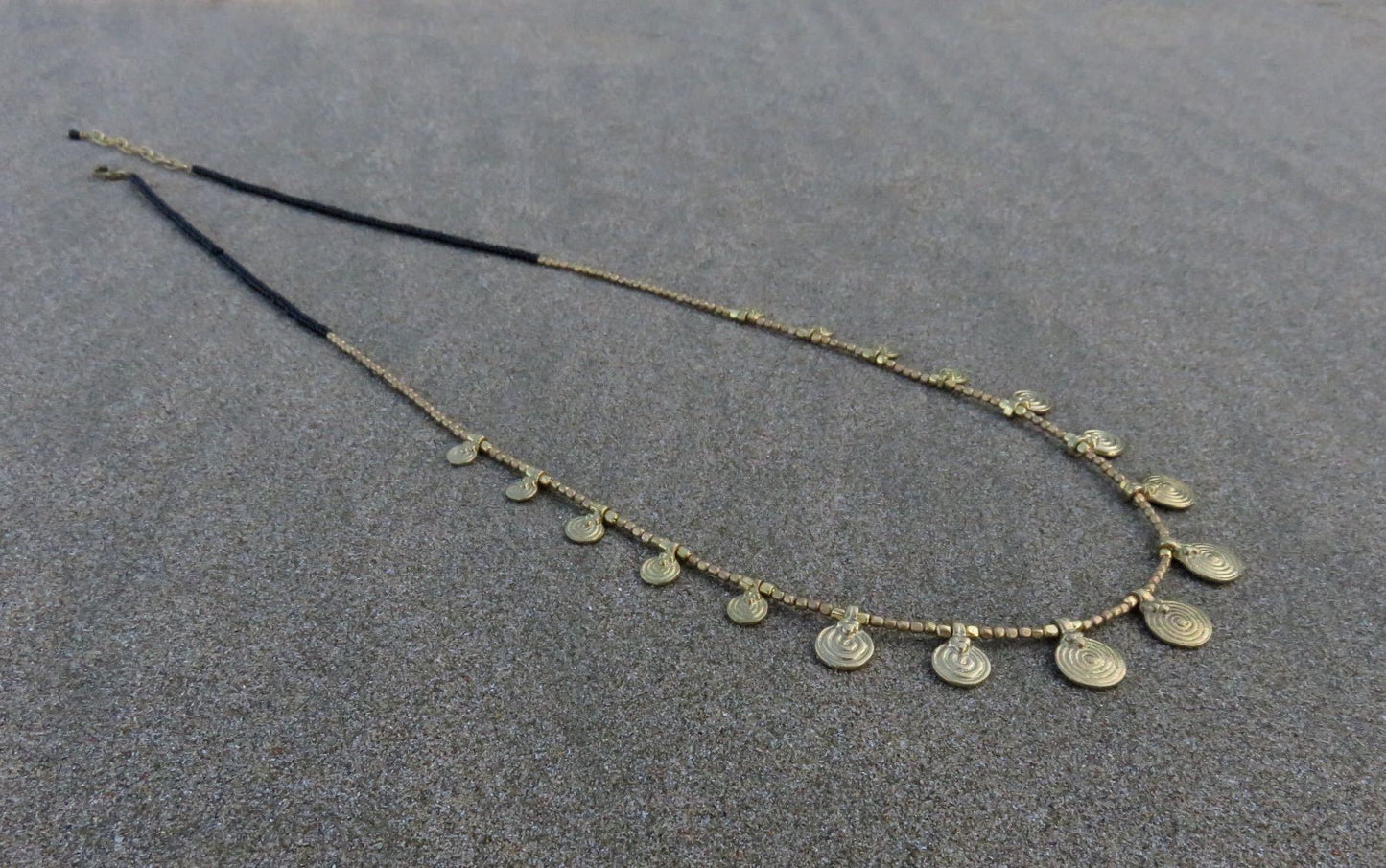 long necklace with brass spirals and black beads