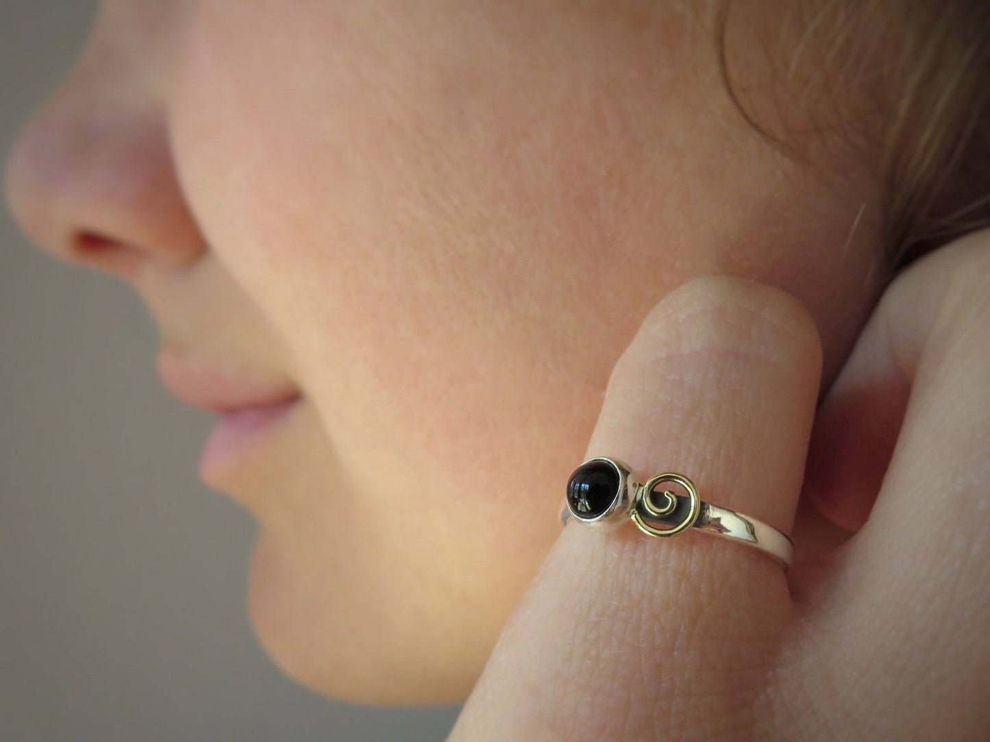Silver ring with spiral made of brass and black stone