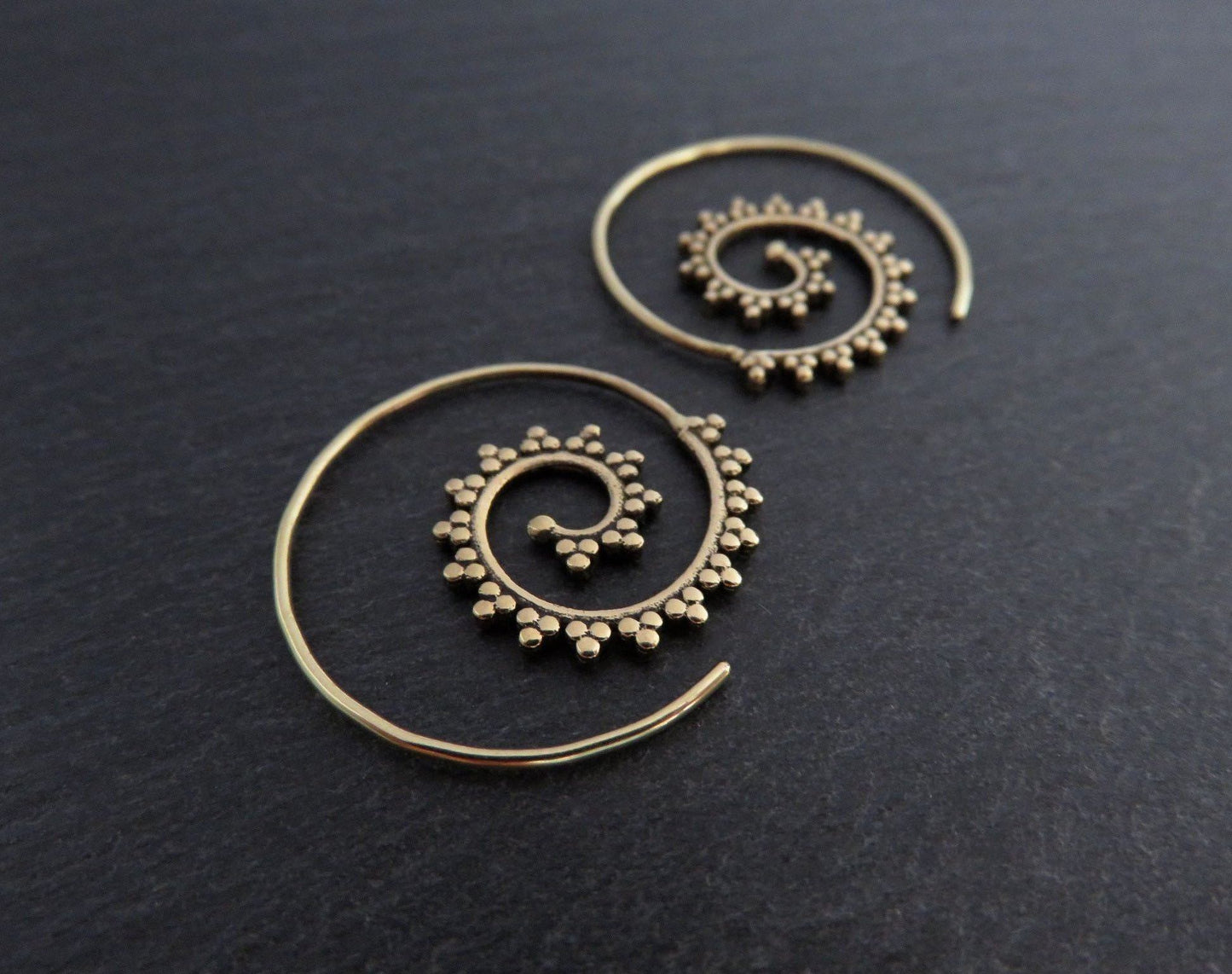 small spiral earrings patterned with small dots made of brass