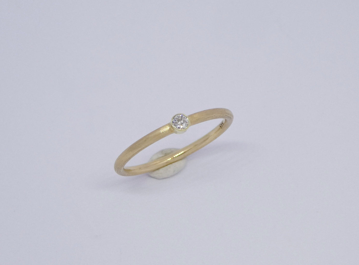 narrow handcrafted gold ring with diamond