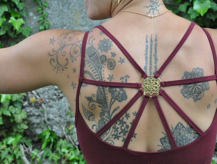 Yoga top with back pattern and brass elements in dark red