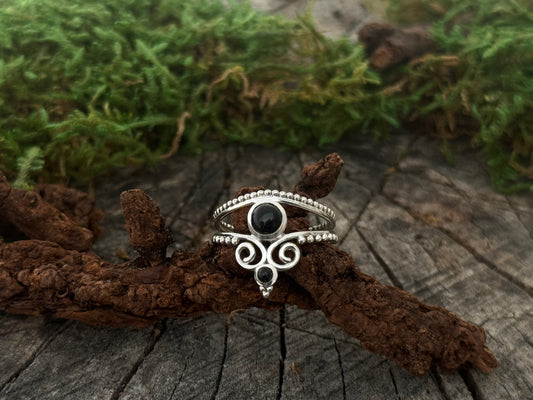 verspielter Ring aus Silber mit Spiralen und Pünktchen sowie zwei schwarzen Steinen