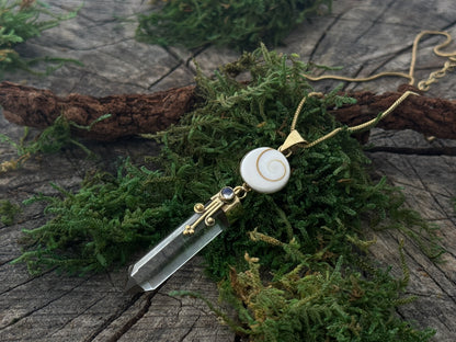 Pendant rock crystal with operculum with spirals, dots and small stone, brass 