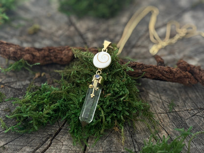 Pendant rock crystal with operculum with spirals, dots and small stone, brass 