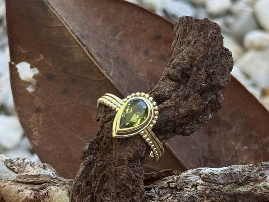 Ring mit facettiertem grünen Peridot in Tropfenform aus Messing