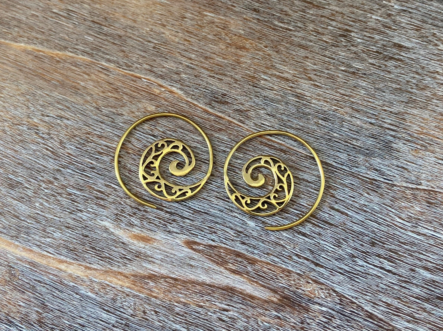 small spiral earrings with a filigree pattern made of brass 