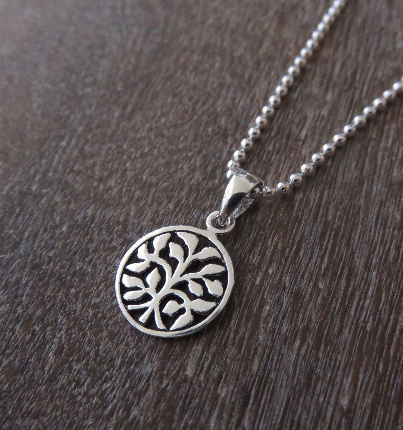 small pendant with leaves on a silver ball chain
