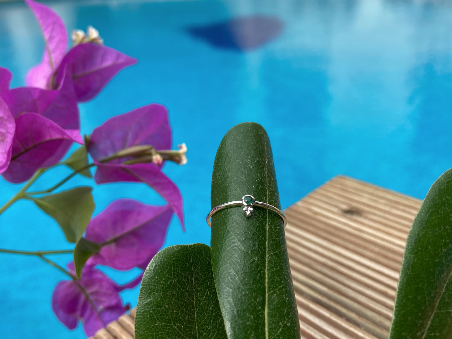 Dainty silver ring with a small faceted green emerald stone and three beads 