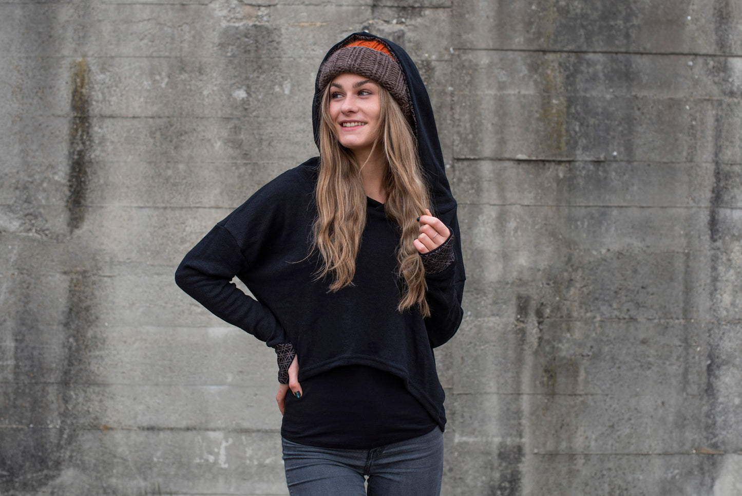 half-length knitted sweater with a patterned hood and thumbholes in black 