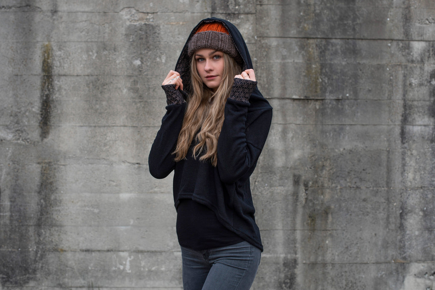 half-length knitted sweater with a patterned hood and thumbholes in black 