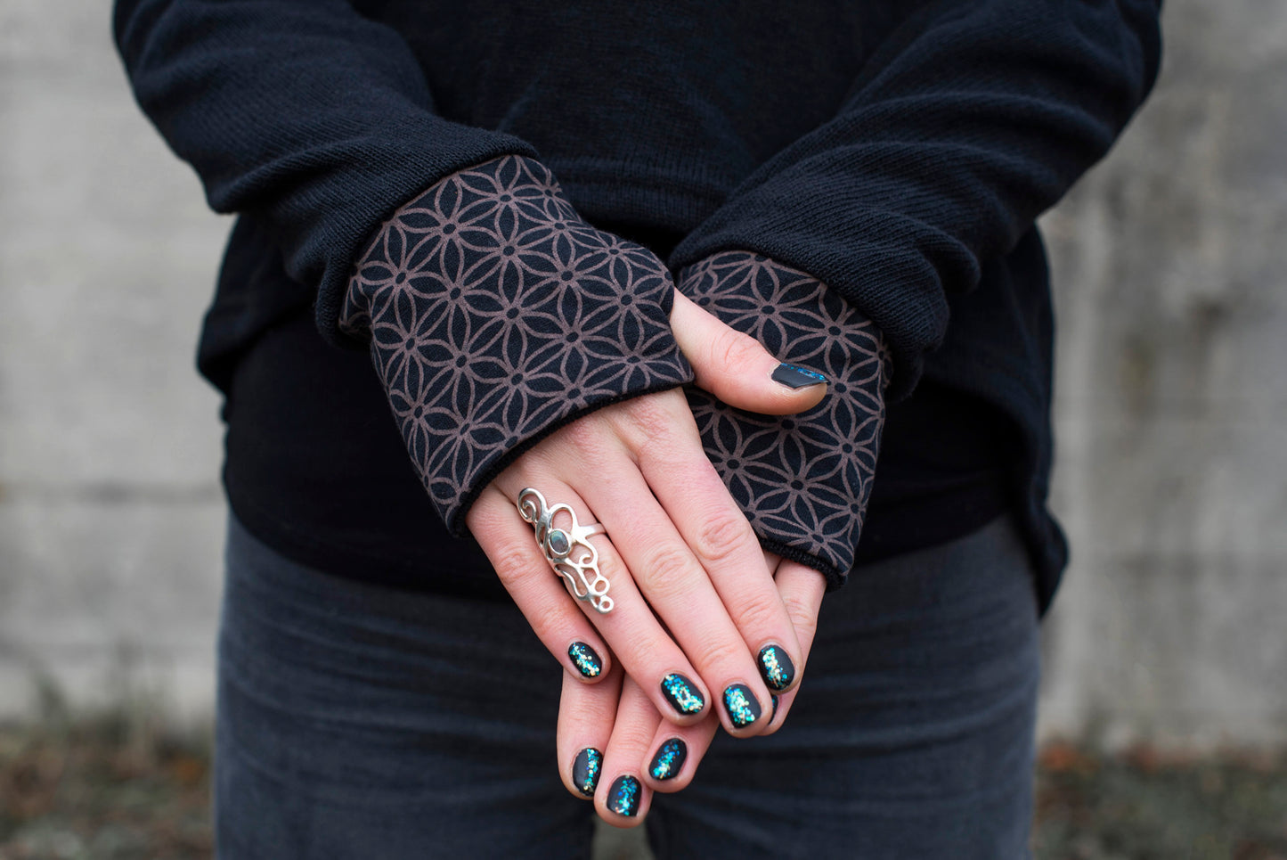 half-length knitted sweater with a patterned hood and thumbholes in black 