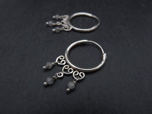 playful hoop earrings each with three dangling silver stones 