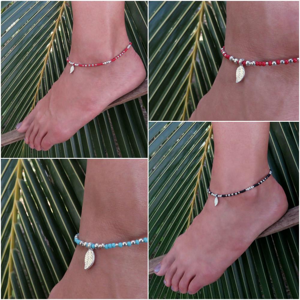 silver-colored anklet with a small leaf and colored beads 