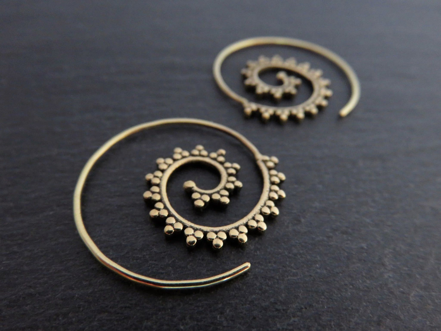small spiral earrings patterned with small dots made of brass 