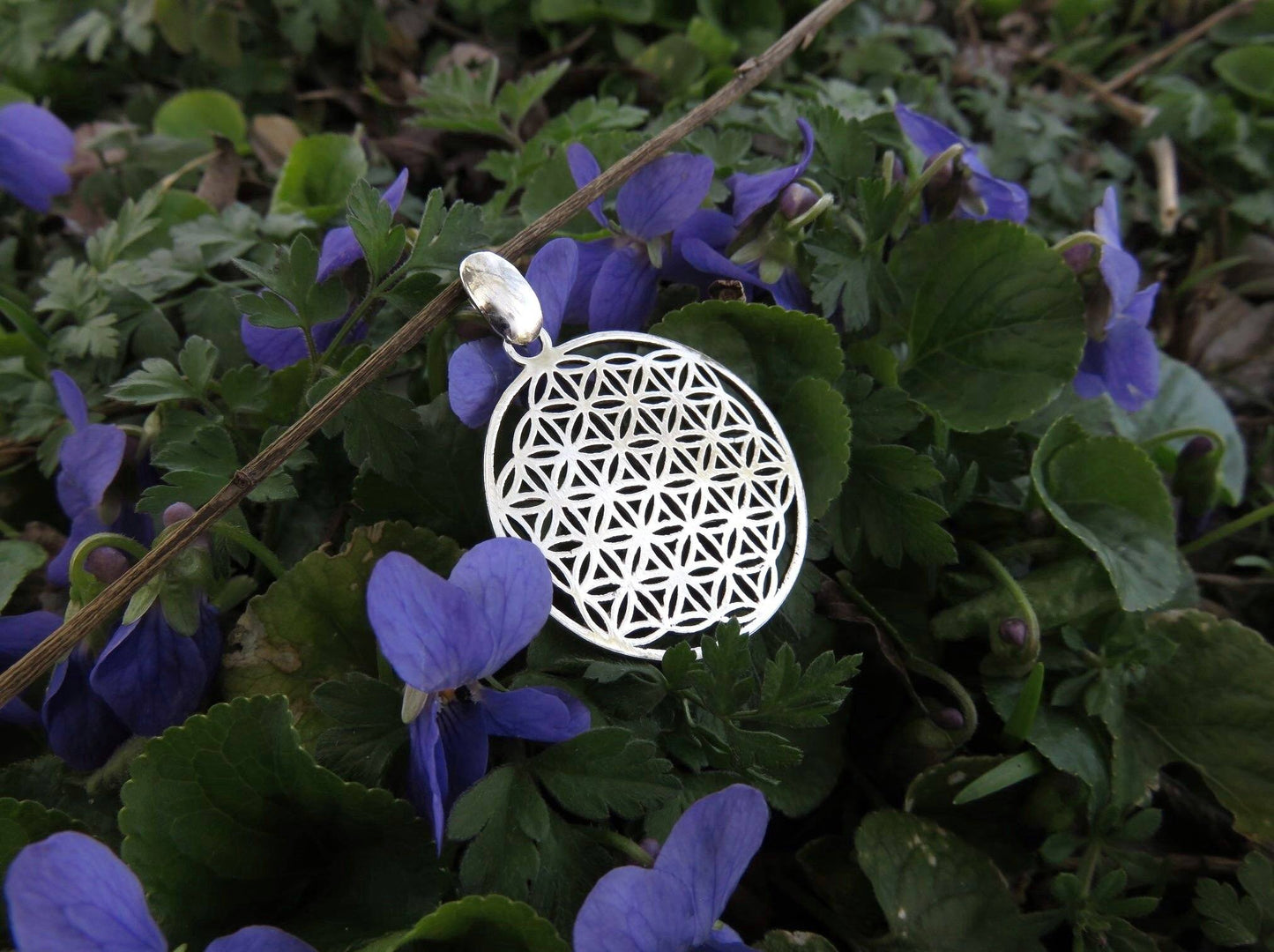 small pendant with the motif of the flower of life made of silver 