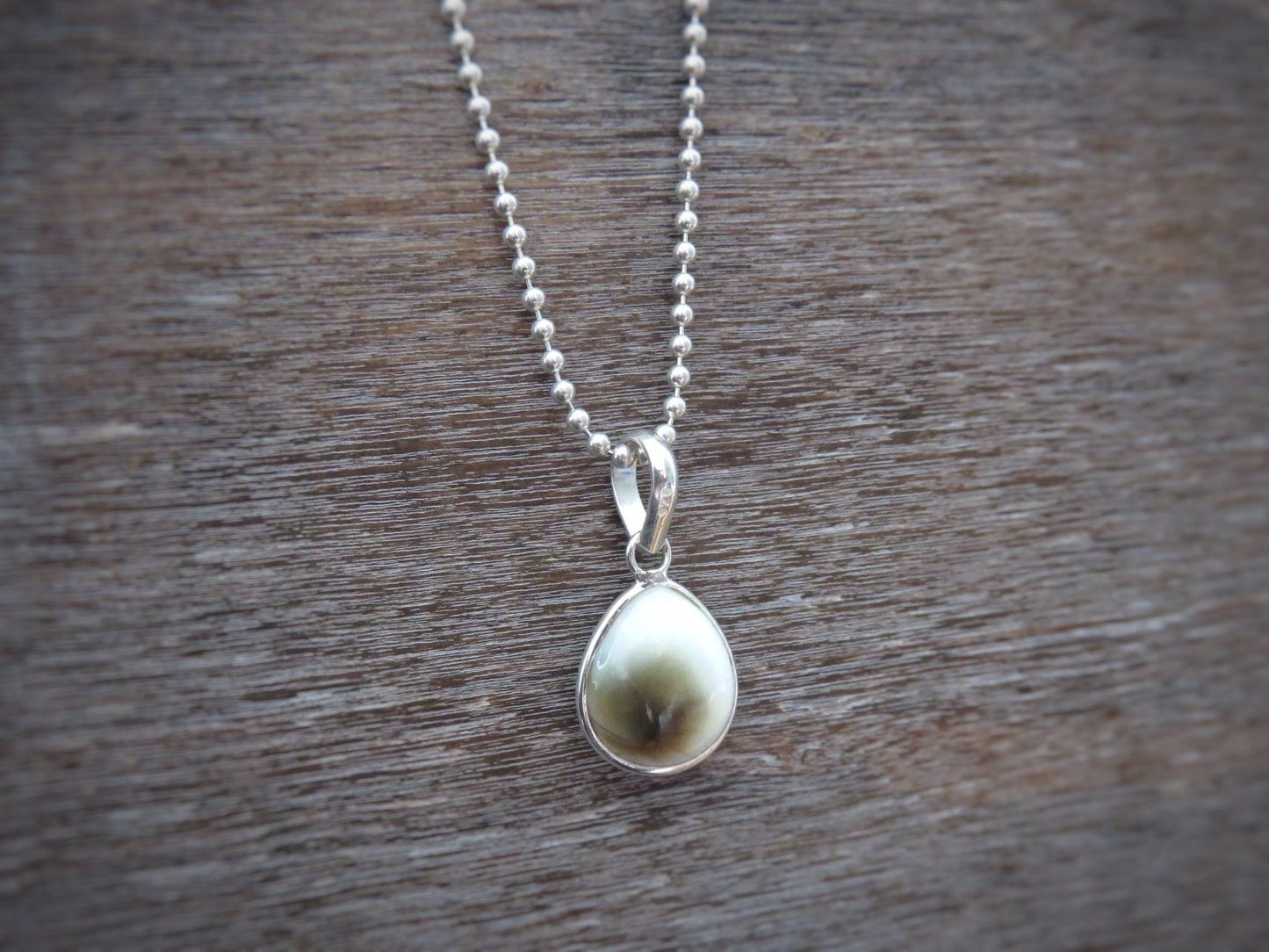 small teardrop-shaped operculum pendant made of silver 